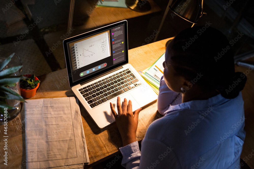 African american woman using laptop for video call, with class on screen