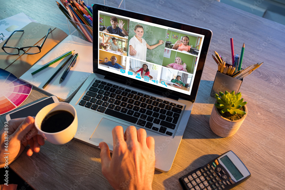 Hands of man using laptop for video call, with smiling diverse elementary school pupils on screen