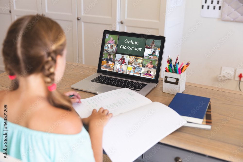 Caucasian girl using laptop for video call, with diverse elementary school pupils on screen