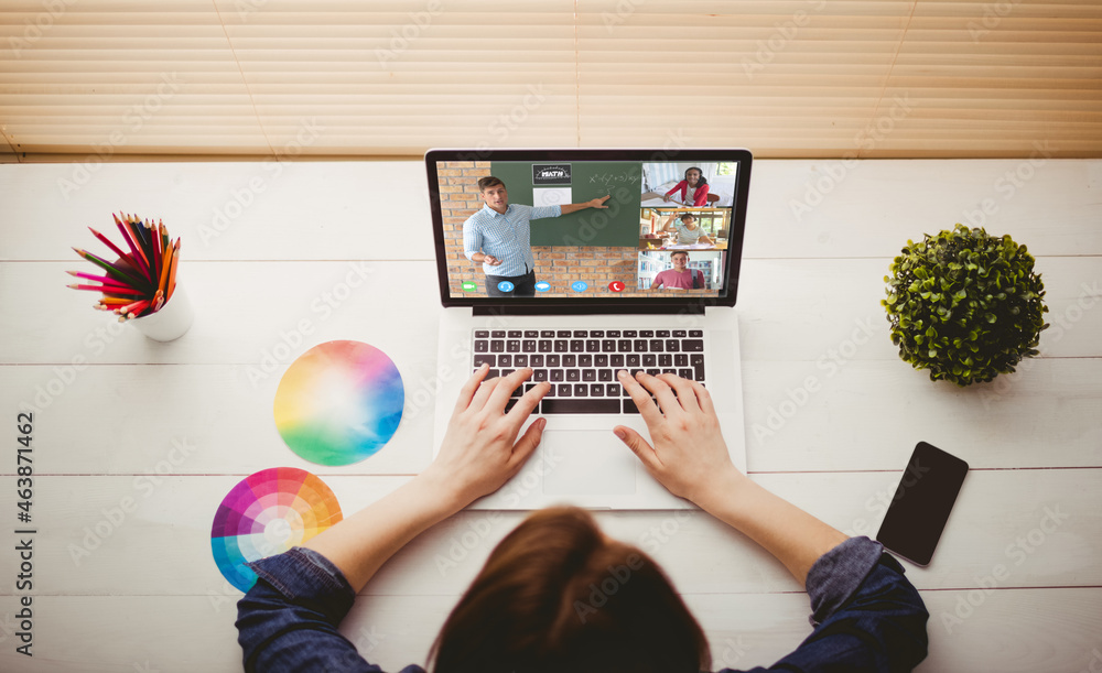 Caucasian woman using laptop for video call, with smiling diverse high school pupils on screen