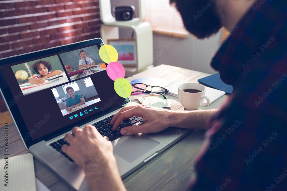 Caucasian man using laptop for video call, with smiling diverse elementary school pupils on screen