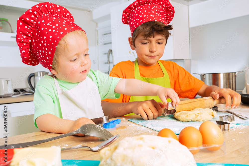 Two brothers cook cookies together at home kitchen