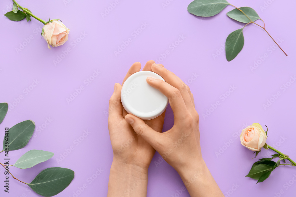 Woman with jar of cosmetic product on color background