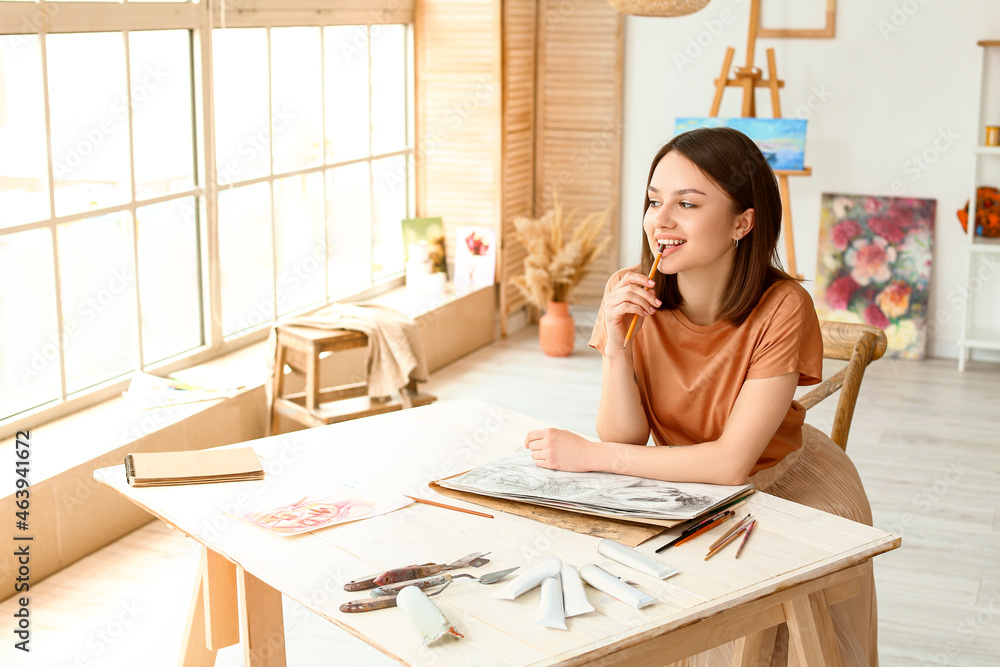 Young female artist drawing in workshop