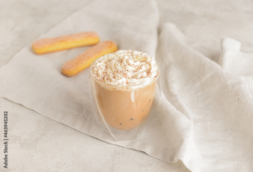 Glass of tasty Tiramisu Latte on light background