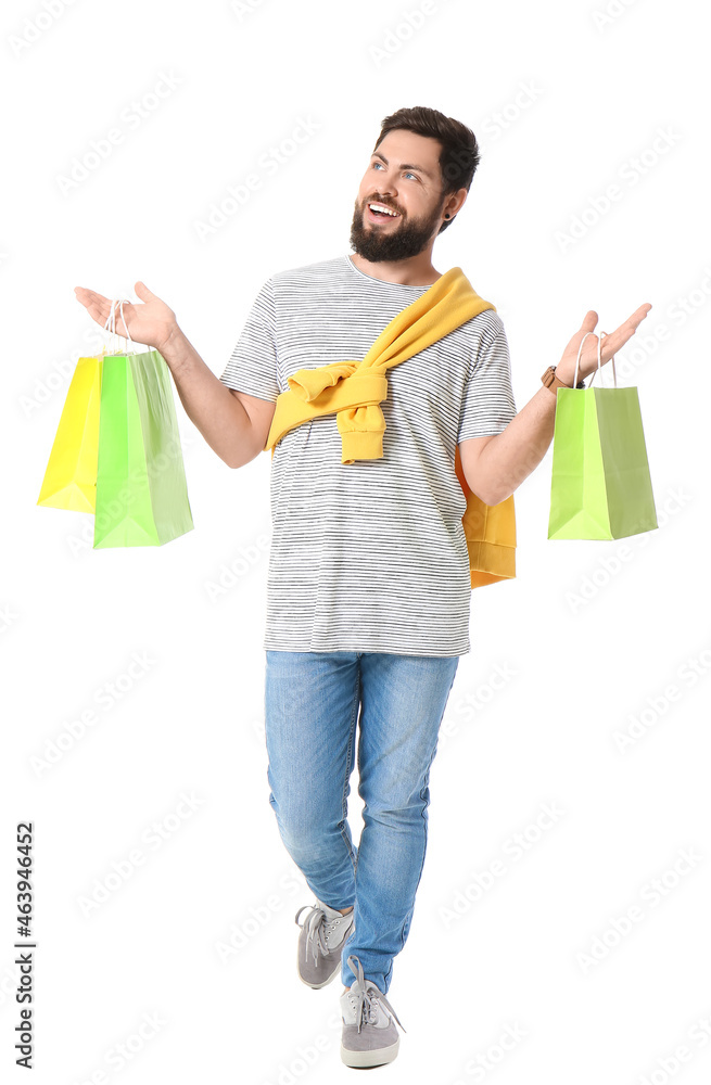 Handsome man with Black Friday shopping bags on white background