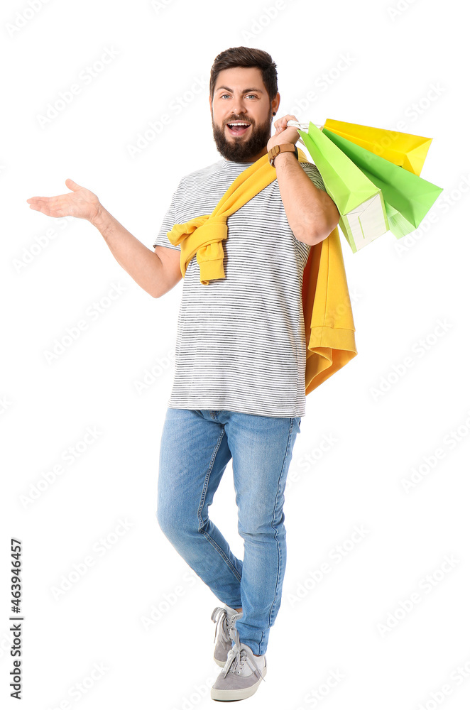 Handsome man with Black Friday shopping bags on white background