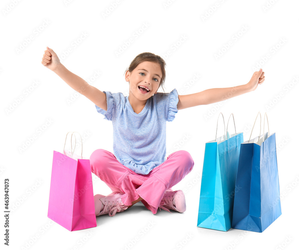 Little girl with Black Friday shopping bags on white background