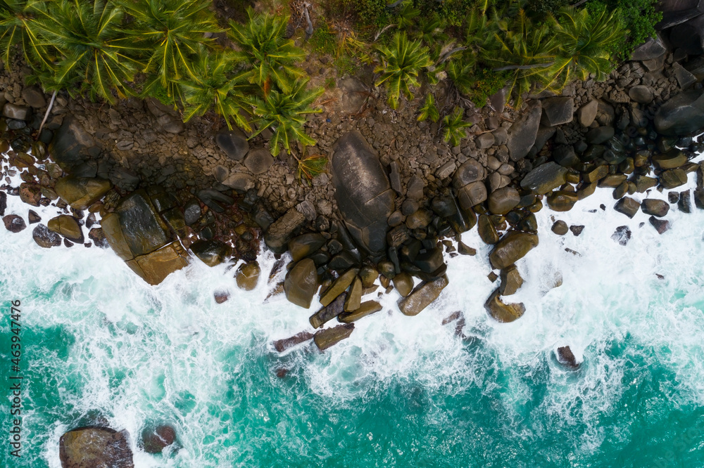 海浪冲击岩石和椰子树的鸟瞰图普吉岛美丽的海滨