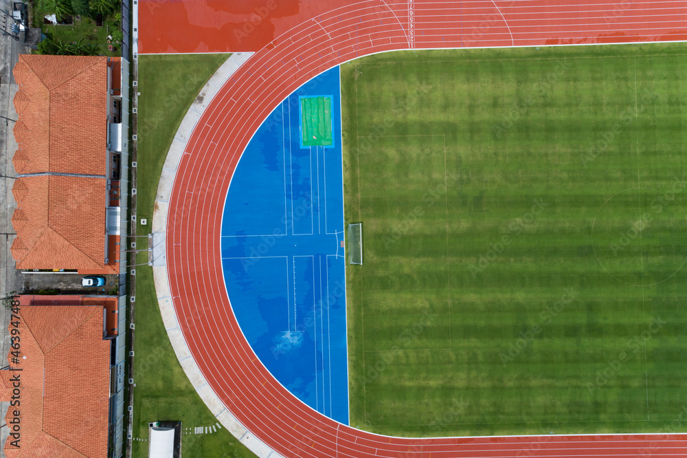 Aerial view of empty new soccer field from above with running tracks around it Amazing new small sta