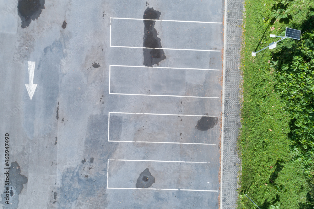 Aerial view top down of empty car parking lot with white line of traffic sign on the street. Above v