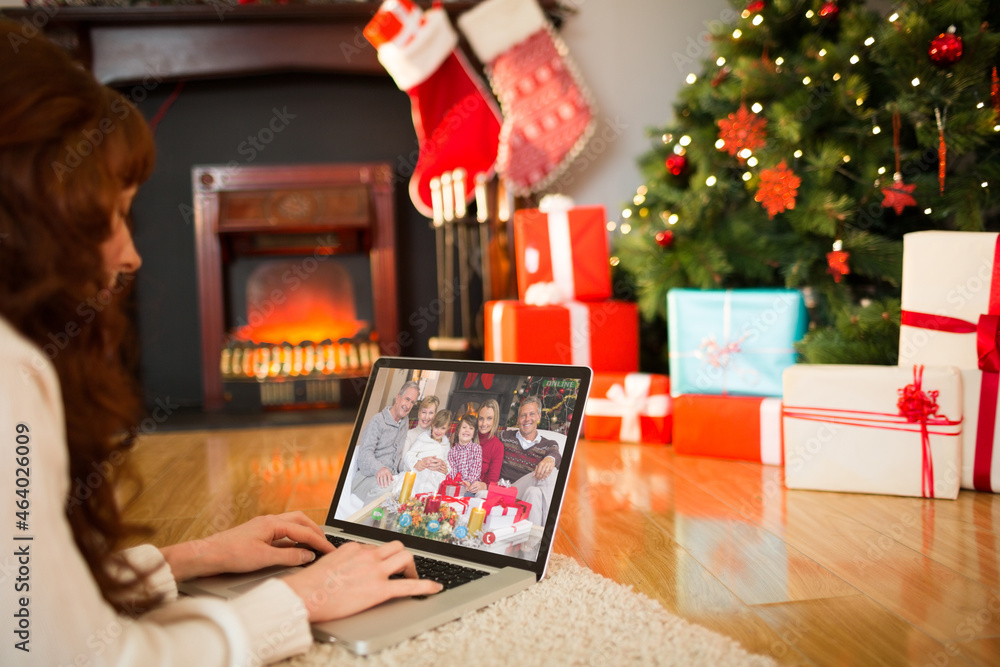 Caucasian woman on christmas laptop video call with multi generation family