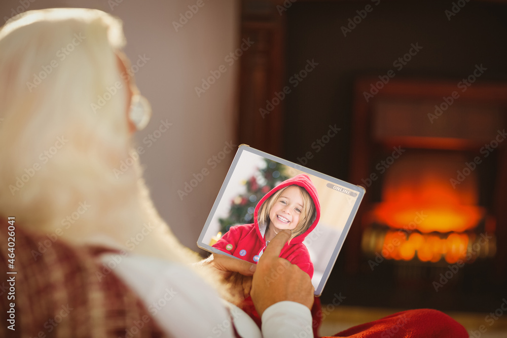 Santa claus making christmas laptop video call with smiling caucasian girl