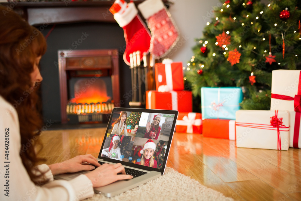 Caucasian woman making christmas laptop video call with smiling caucasian female friends