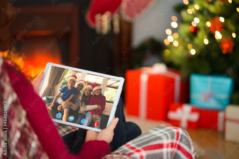 Caucasian woman making tablet christmas video call with smiling caucasian family