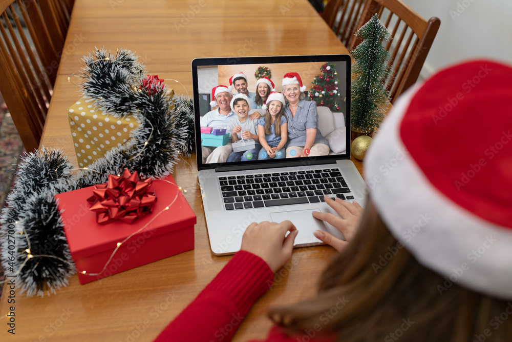 Caucasian woman on christmas laptop video call with caucasian family