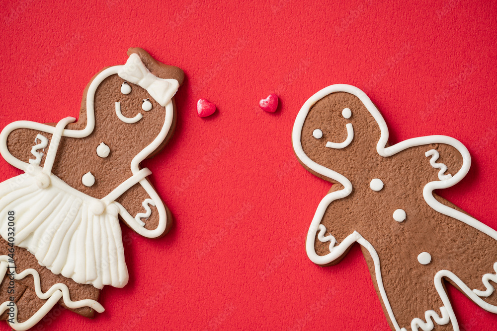 Decorated Christmas gingerbread cookies on red table background.