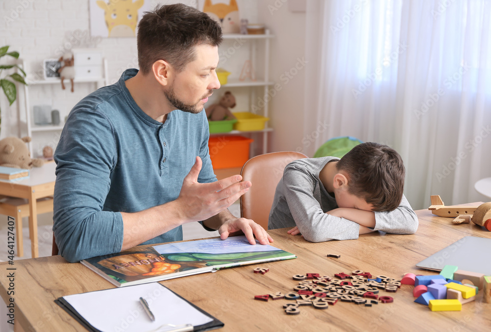 Male psychologist working with little boy in office. Autism concept