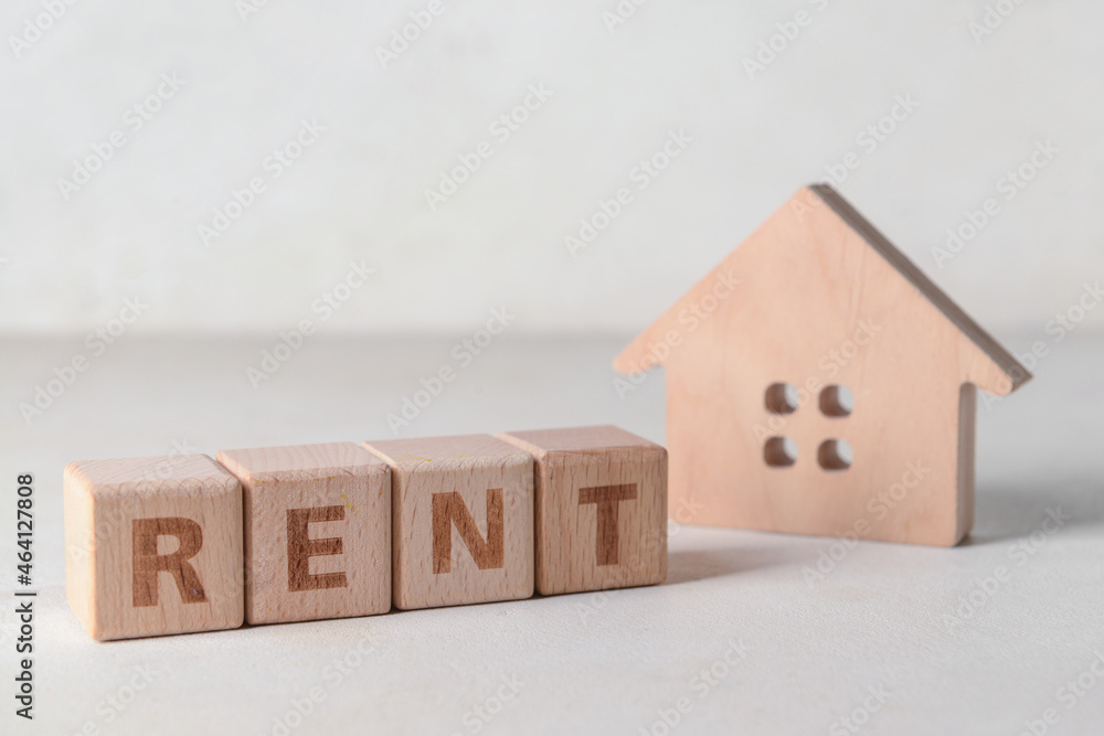 Wooden house with word RENT on white background