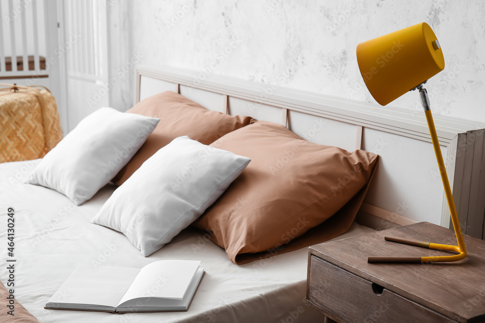 Yellow lamp on wooden bedside table in light room