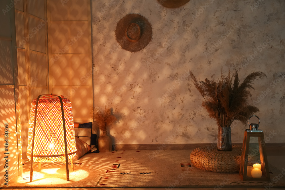 Glowing wicker lantern in interior of dark room