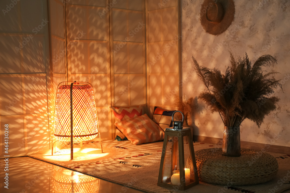 Glowing wicker lantern in interior of dark room