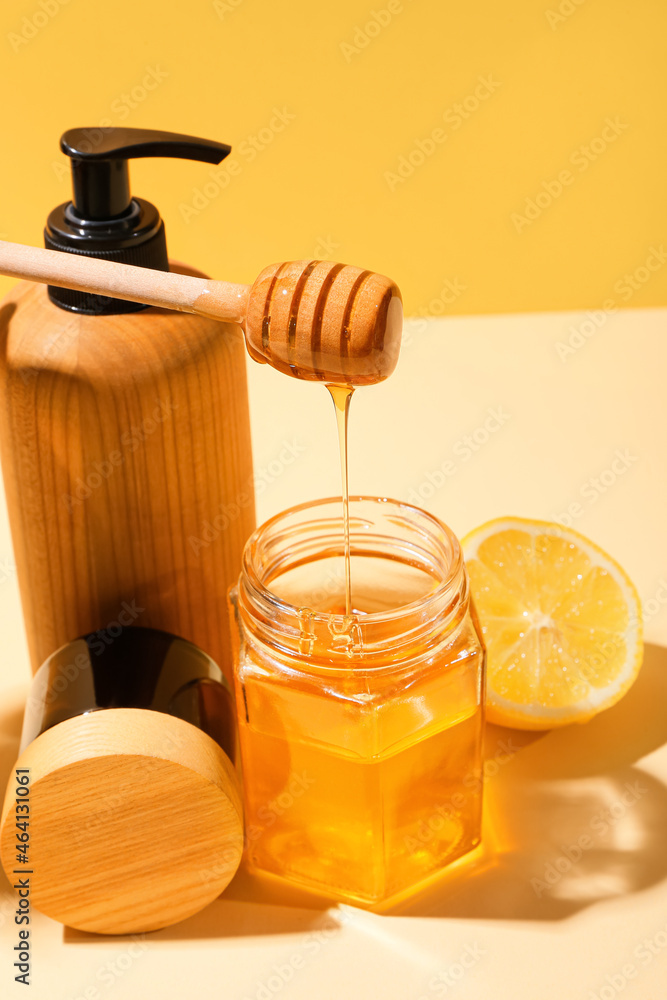 Composition with cosmetic products, honey and lemon on color background, closeup