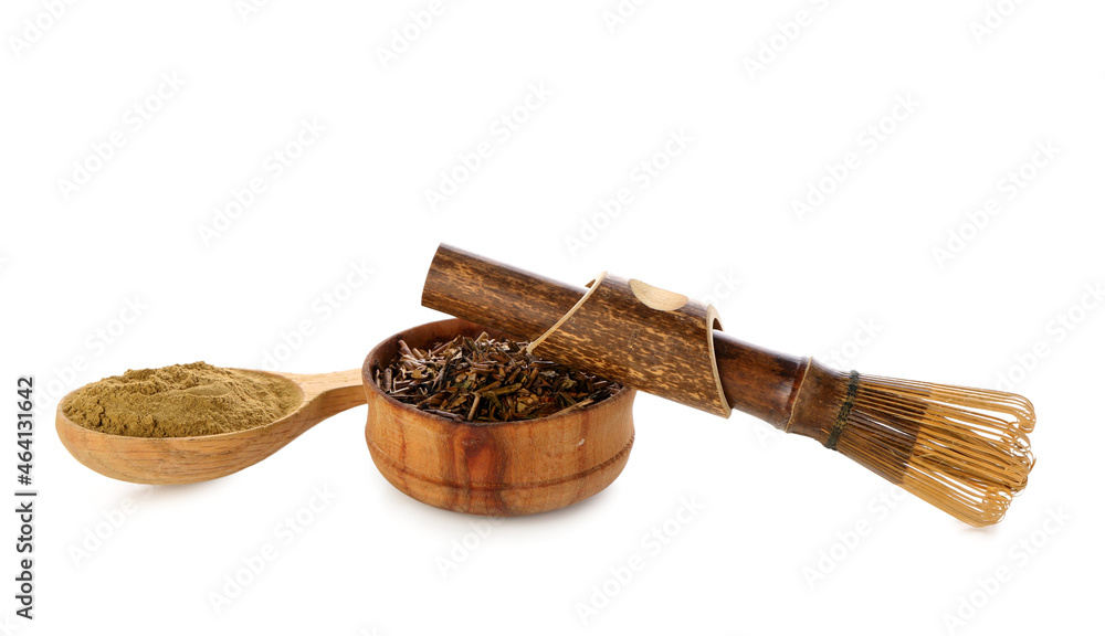 Bowl with spoon of hojicha powder and chasen on white background