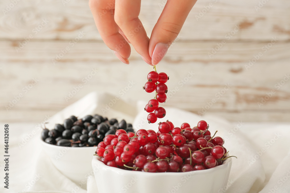 Woman with different ripe berries on table, closeup