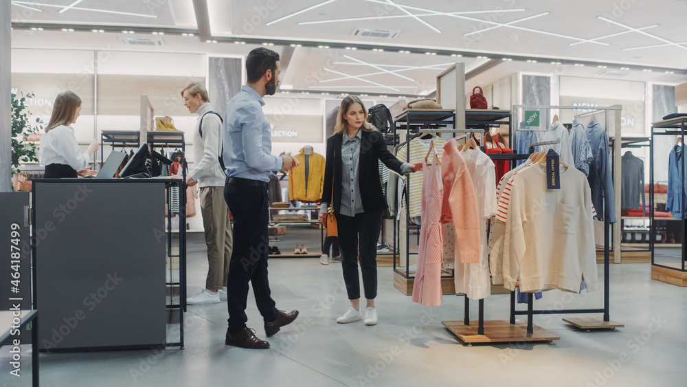 Beautiful Female Customer Shopping in Clothing Store, Retail Sales Associate Helps with Advice. Dive