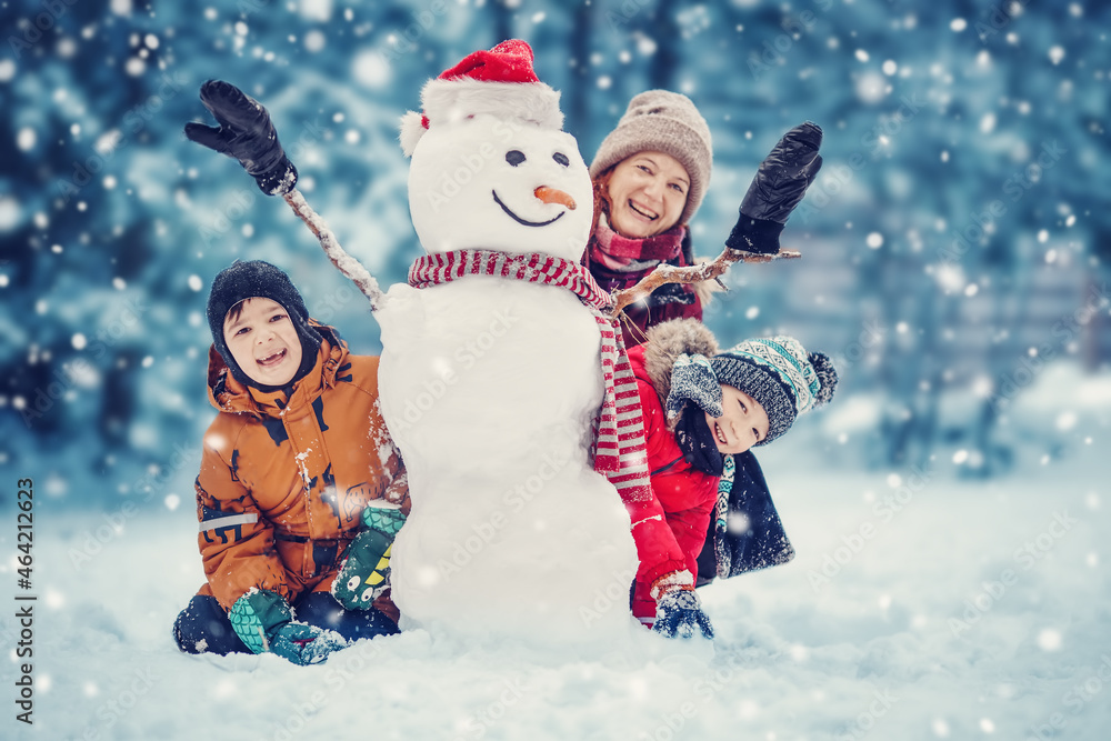 Mother and her children playing in the winter park