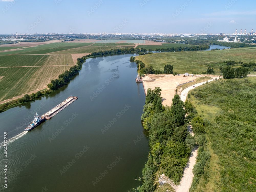 A cargo barge floats on a small river