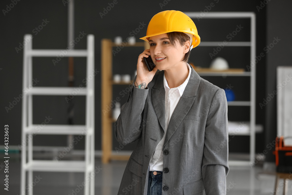 Female industrial engineer talking by mobile phone in office