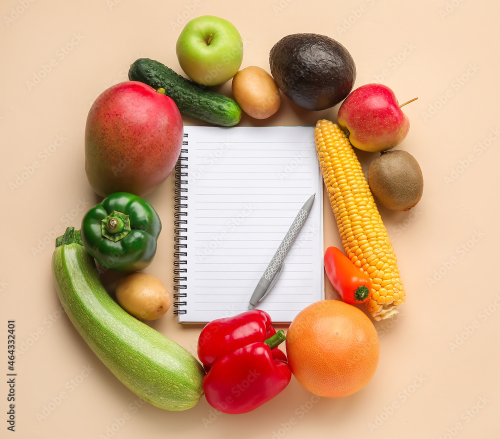 Blank notebook, pen, fruits and vegetables on color background. Vegan Day