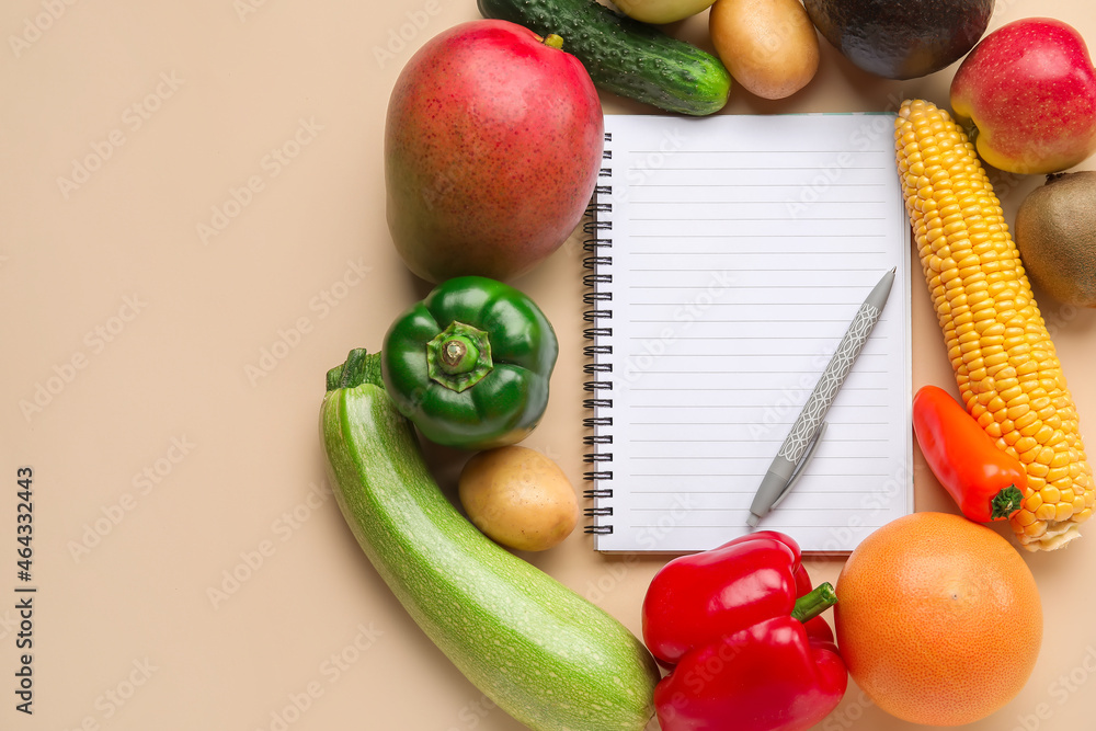 空白笔记本、钢笔、彩色背景的水果和蔬菜。素食日