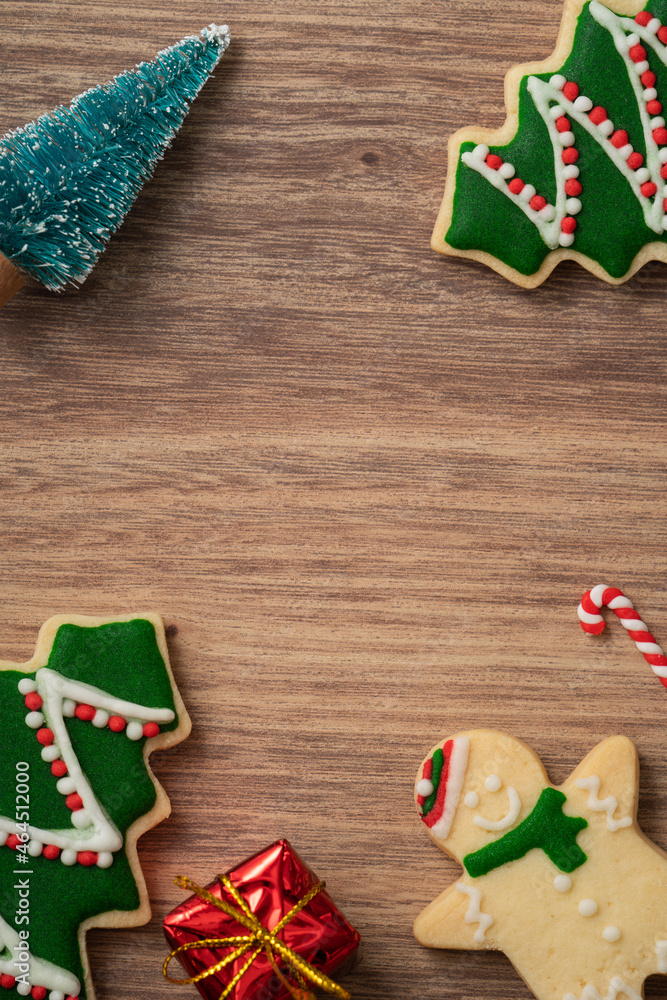 Decorated Christmas gingerbread cookies with decorations on wooden table background.