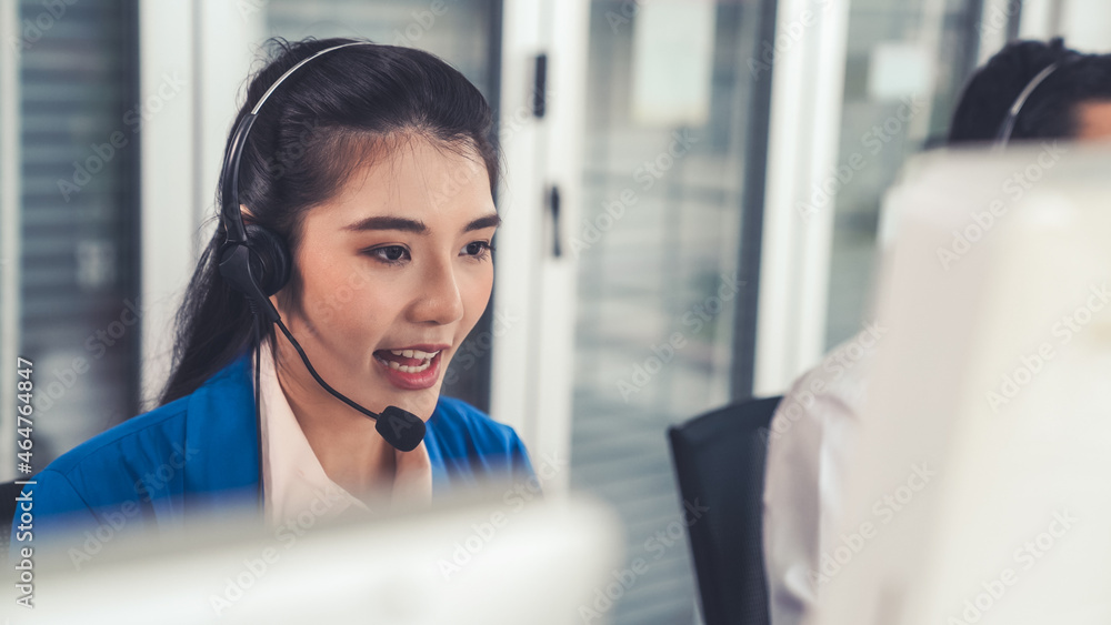 Businesswoman wearing headset working actively in office . Call center, telemarketing, customer supp