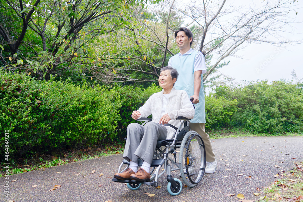 高齢者の車椅子を押す介護士