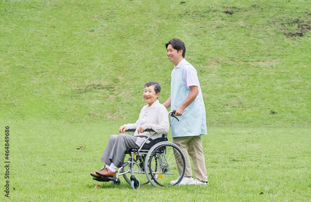 高齢者の車椅子を押す介護士