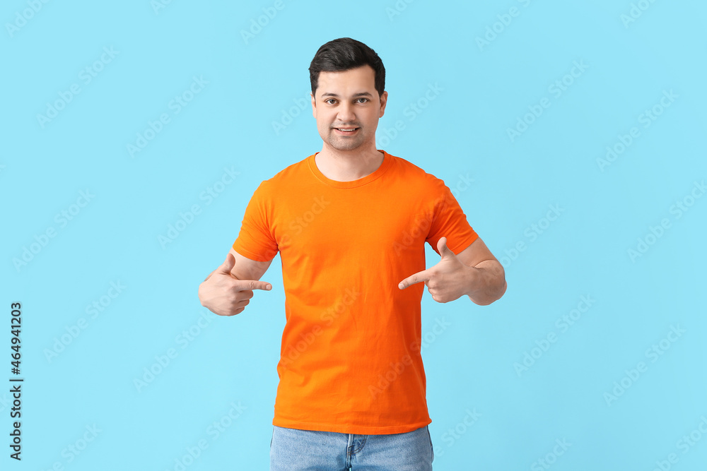 Handsome young man in stylish t-shirt on color background