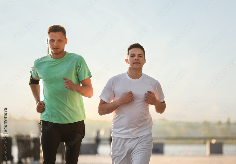 Sporty young men running outdoors