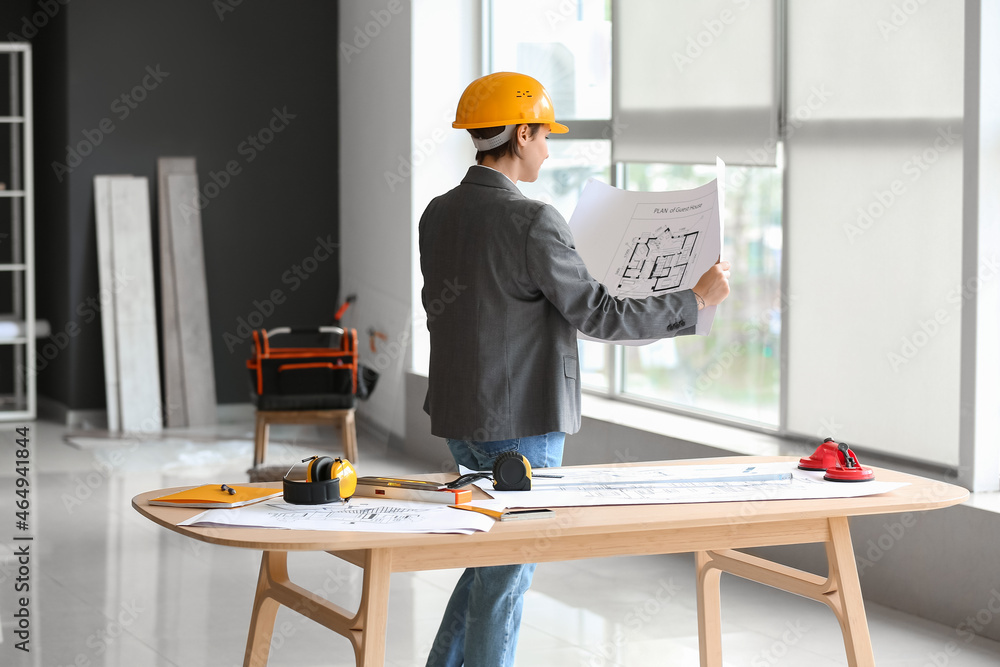 Female industrial engineer with house plan in office