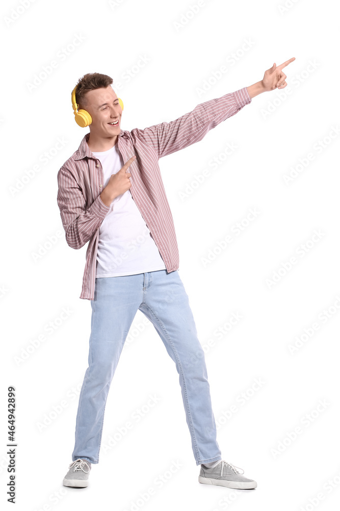 Young man in headphones listening to music on white background