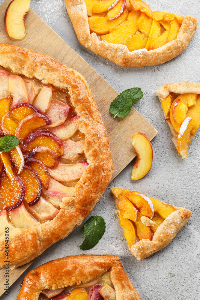 Composition with tasty peach galette on light background