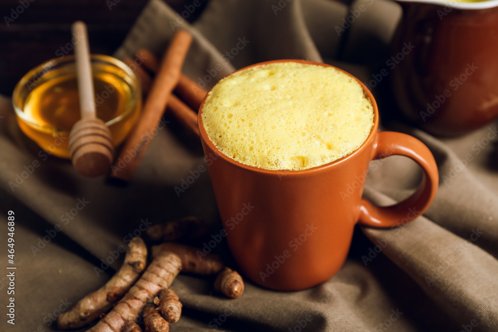 Cup of healthy turmeric latte on table, closeup