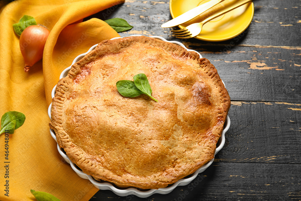 Baking dish with tasty chicken pot pie on black wooden background