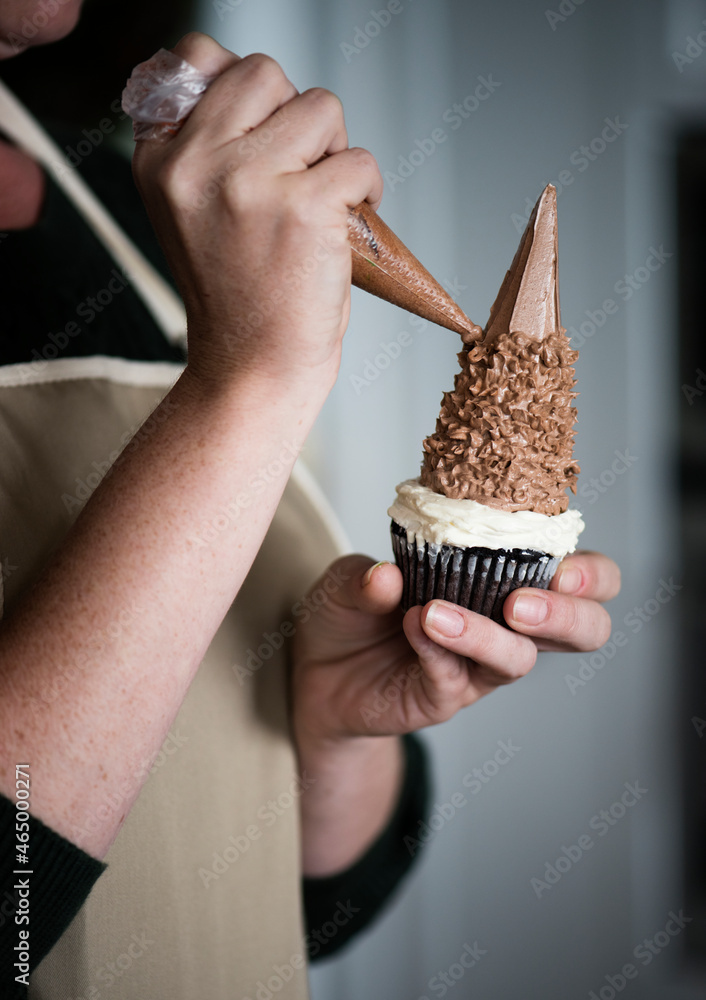 Woman decorating a cupcake