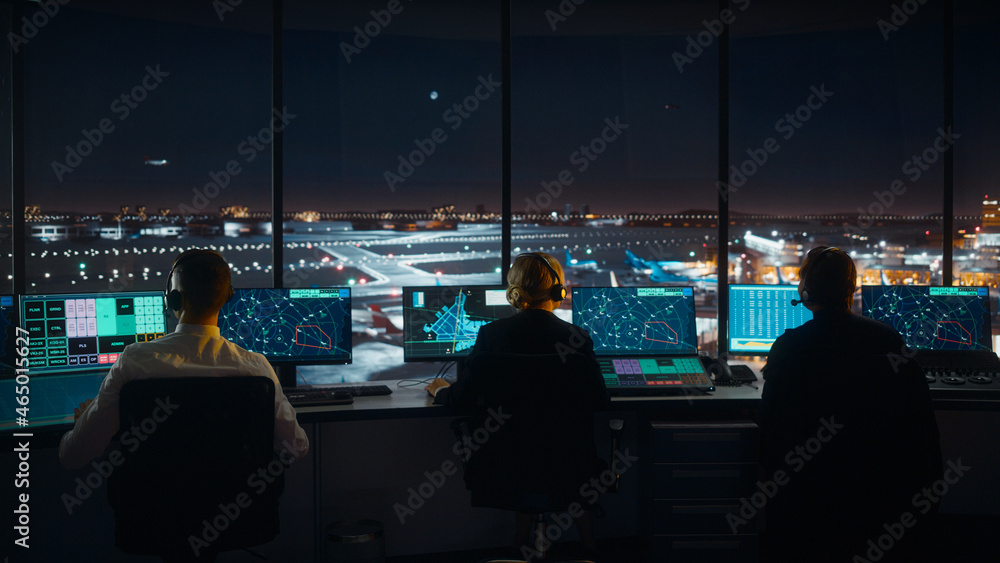 Diverse Air Traffic Control Team Working in Modern Airport Tower at Night. Office Room Full of Deskt