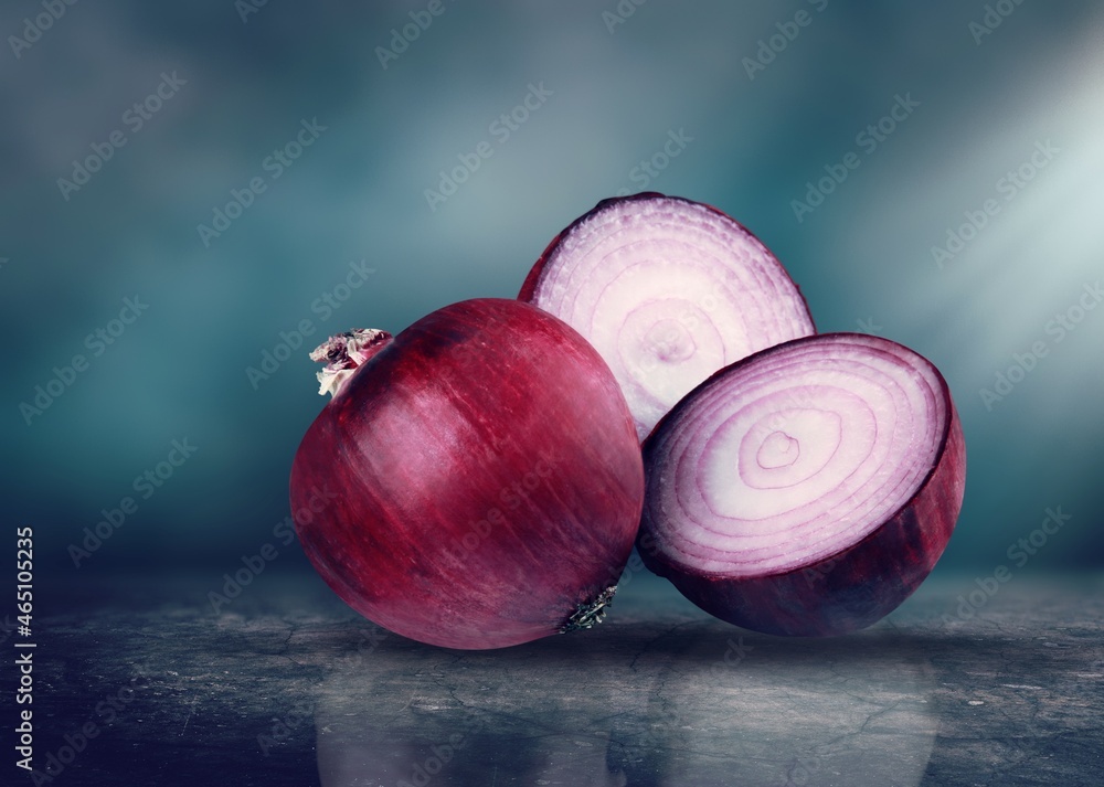 Red whole and sliced onion on the desk