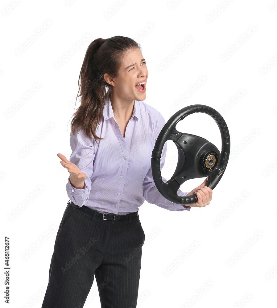 Angry young businesswoman with steering wheel on white background